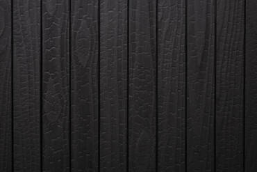 Close-up texture detail of vertical charredwoodcanada ltd deep black Thermo Pinus Radiata charred wood cladding boards, featuring a heavily charred surface with a prominent crackled Yakisugi pattern and matte finish.
