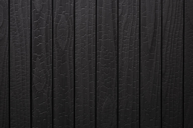 Close-up texture detail of vertical charredwoodcanada ltd deep black Thermo Pinus Radiata charred wood cladding boards, featuring a heavily charred surface with a prominent crackled Yakisugi pattern and matte finish.