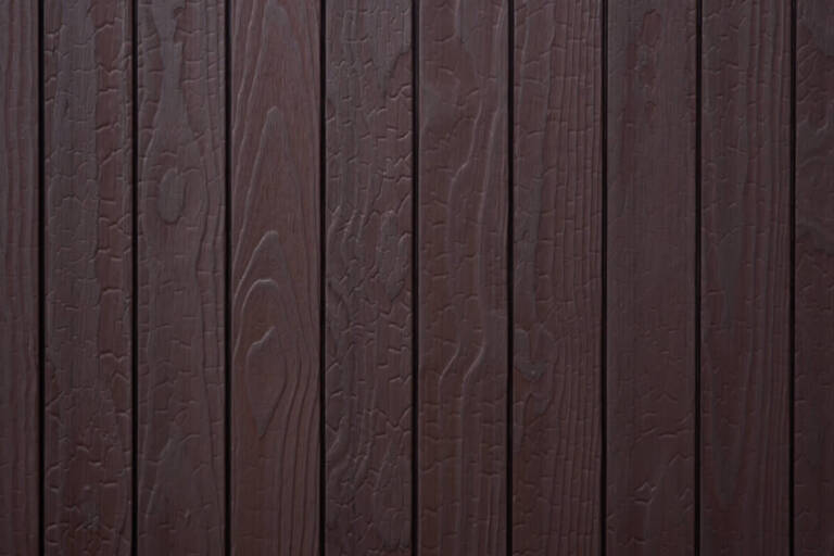 Close-up texture detail of vertical charredwoodcanada ltd dark brown Thermo Pinus Radiata charred wood cladding boards, featuring a brushed surface that highlights the wood grain and crackled Shou Sugi Ban charring patterns.