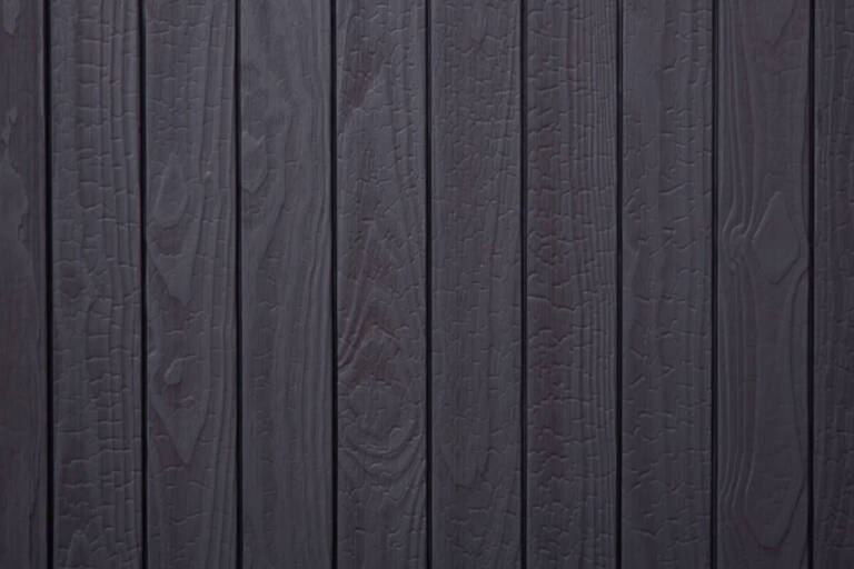 Close-up texture detail of vertical charredwoodcanada ltd charcoal grey Thermo Pinus Radiata charred wood cladding boards, featuring a brushed surface that highlights the raised wood grain, natural knots, and distinct crackled Yakisugi charring patterns.