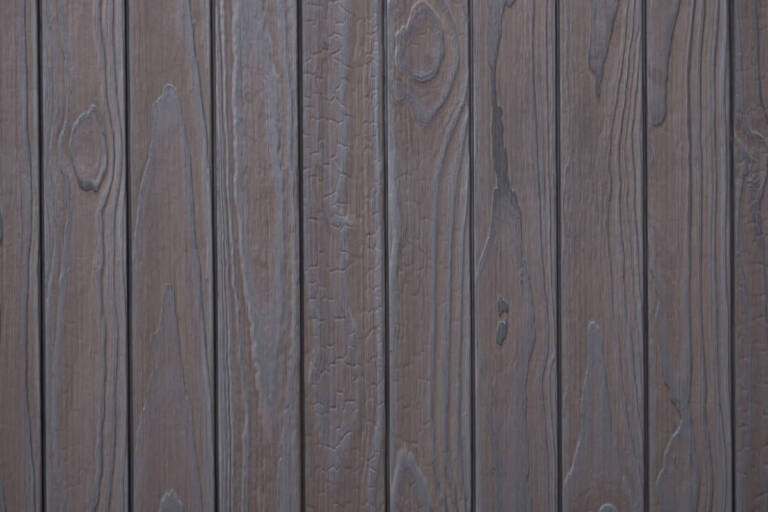 Close-up texture detail of vertical charredwoodcanada ltd light grey Thermo Pinus Radiata charred wood cladding boards, featuring a brushed surface that highlights the raised wood knots, deep grain textures, and dark Yakisugi charring.