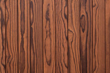 Close-up texture detail of vertical charredwoodcanada ltd natural unoiled Thermo Pinus Radiata charred wood cladding boards, displaying a brushed surface that reveals distinct wood knots, heavy grain, and dark Yakisugi charring patterns.